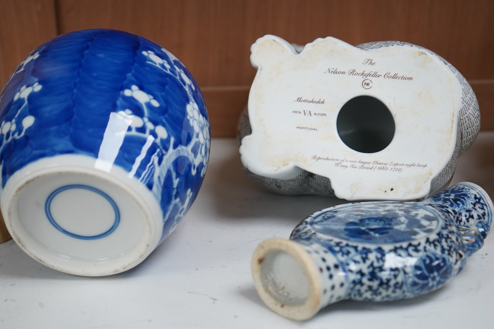 A 19th century Chinese blue and white small moon flask together with a later jar and a Portugese porcelain copy of a Chinese export cat, largest 19cm high